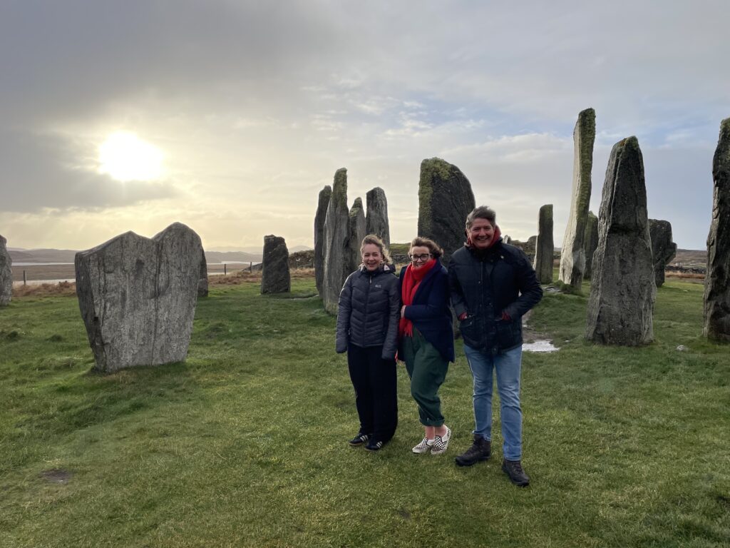 Billie, Kathryn and James stand in front of the Standing Stones in the blustery wind