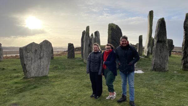Billie, Kathryn and James stand in front of the Standing Stones in the blustery wind